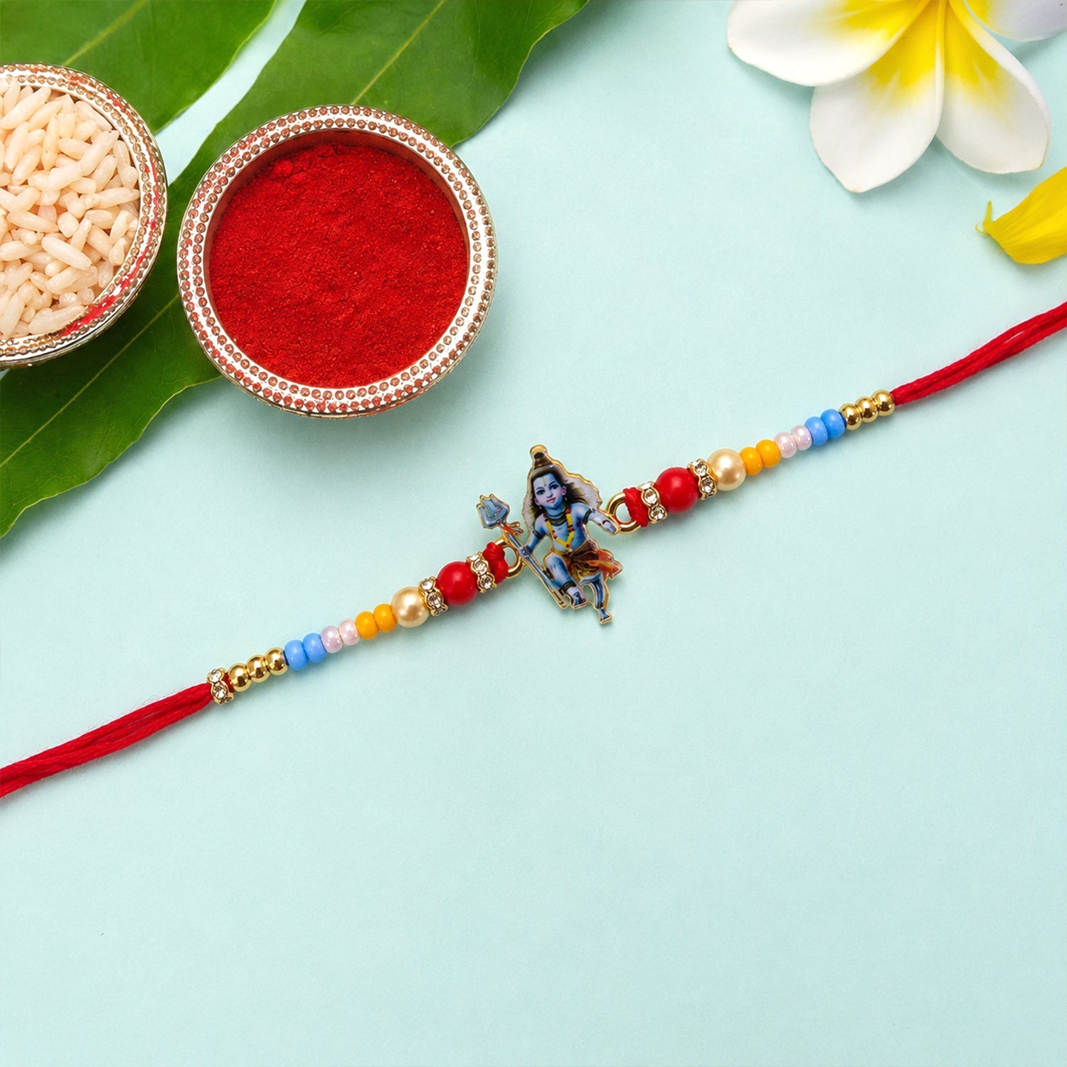 Close-up of designer rakhi with Mahadev idol and beads