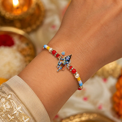 Elegant Mahadev idol rakhi tied on wooden surface
