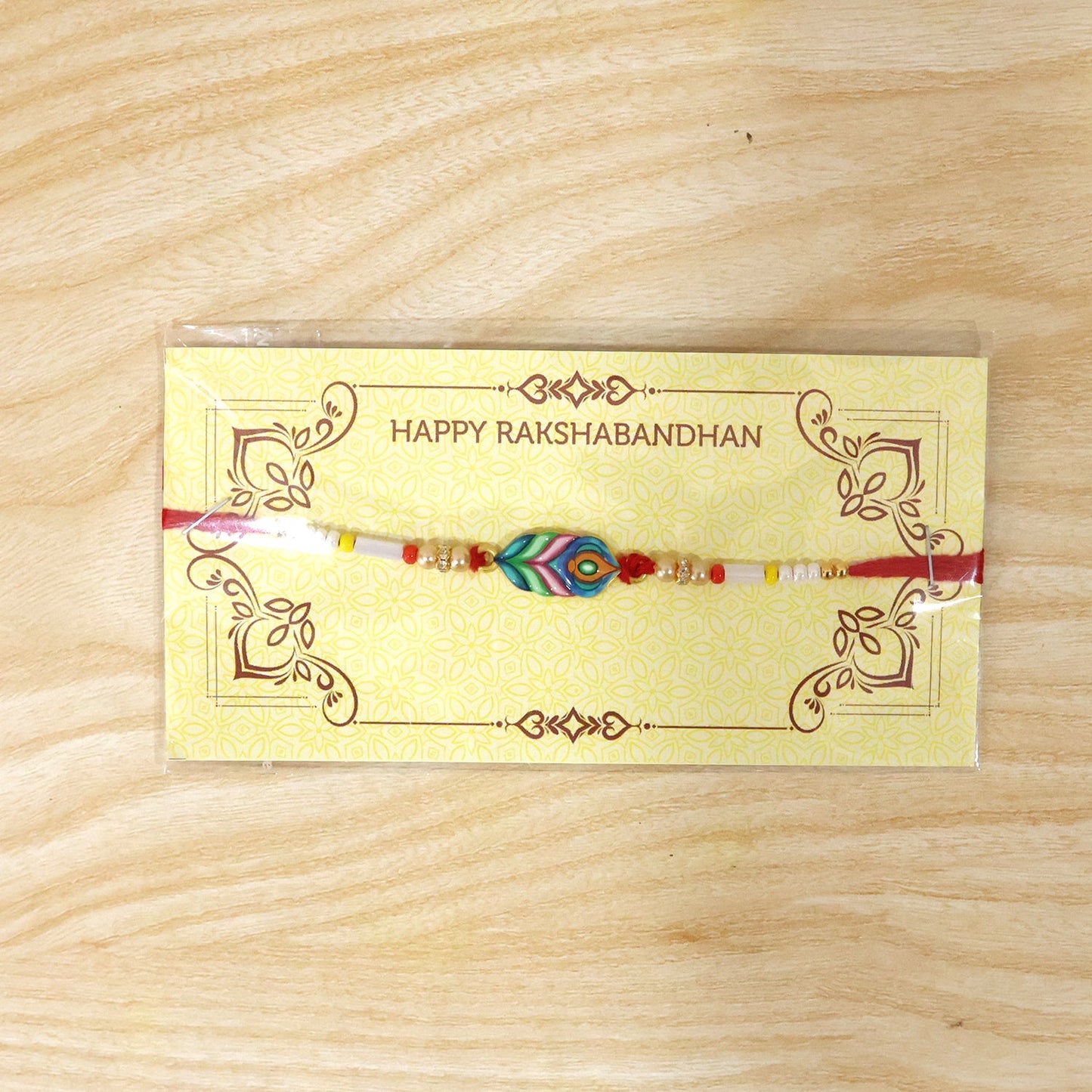 Close-up of handmade beaded rakhi with Mor Pankh charm