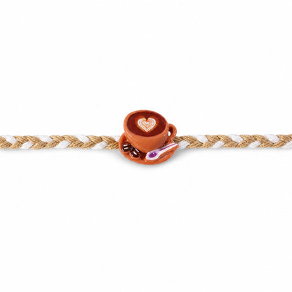 Top view of coffee cup heart charm rakhi with braided thread