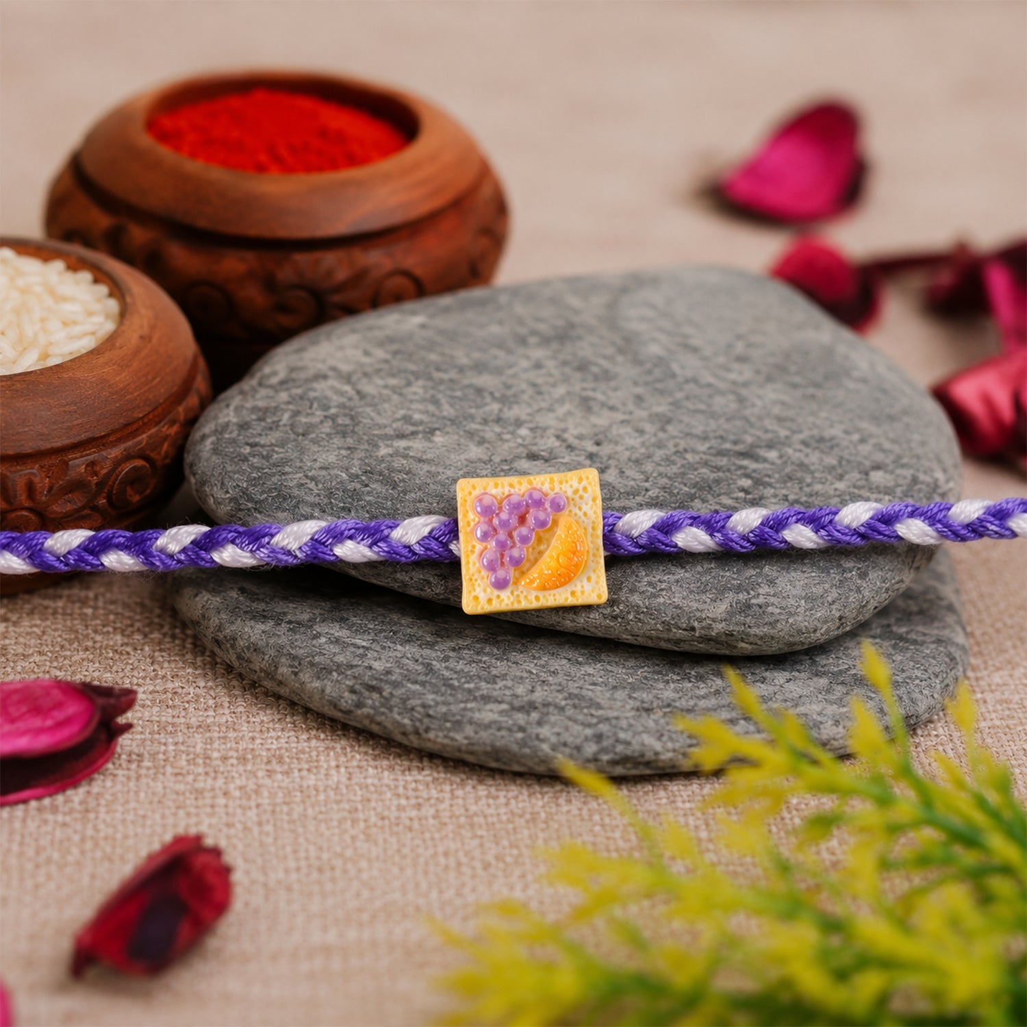 Side angle of Fruit Toast Charm Rakhi showing braided thread