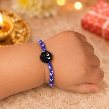 Side view of braided thread rakhi with cookie eyes charm