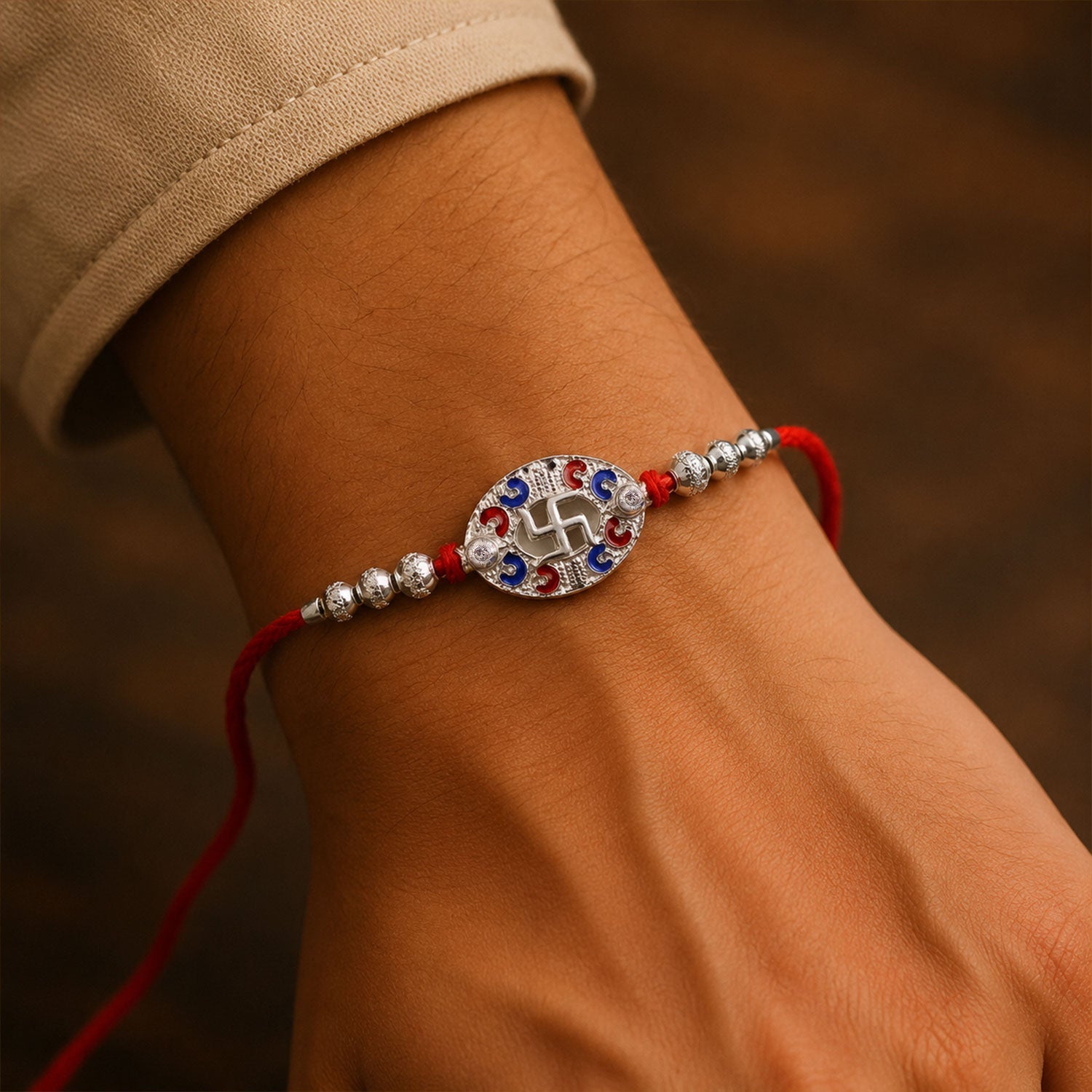 Side angle of Silver Swastik Oval Meena Charm Rakhi with dori