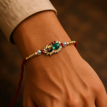 Close-up of peacock emerald stone and pearl beads on Rakhi