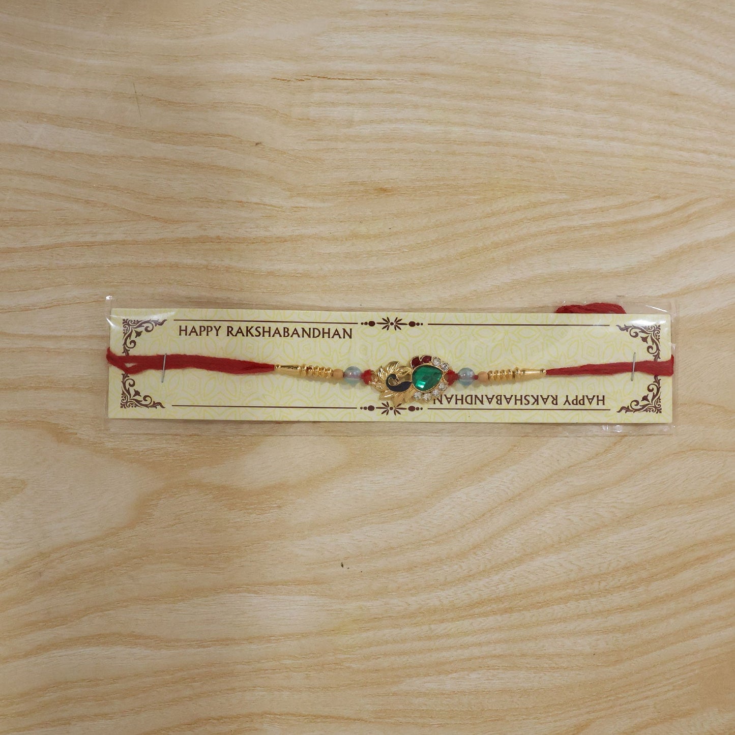Peacock Emerald Stone Rakhi with pearl beads packaging