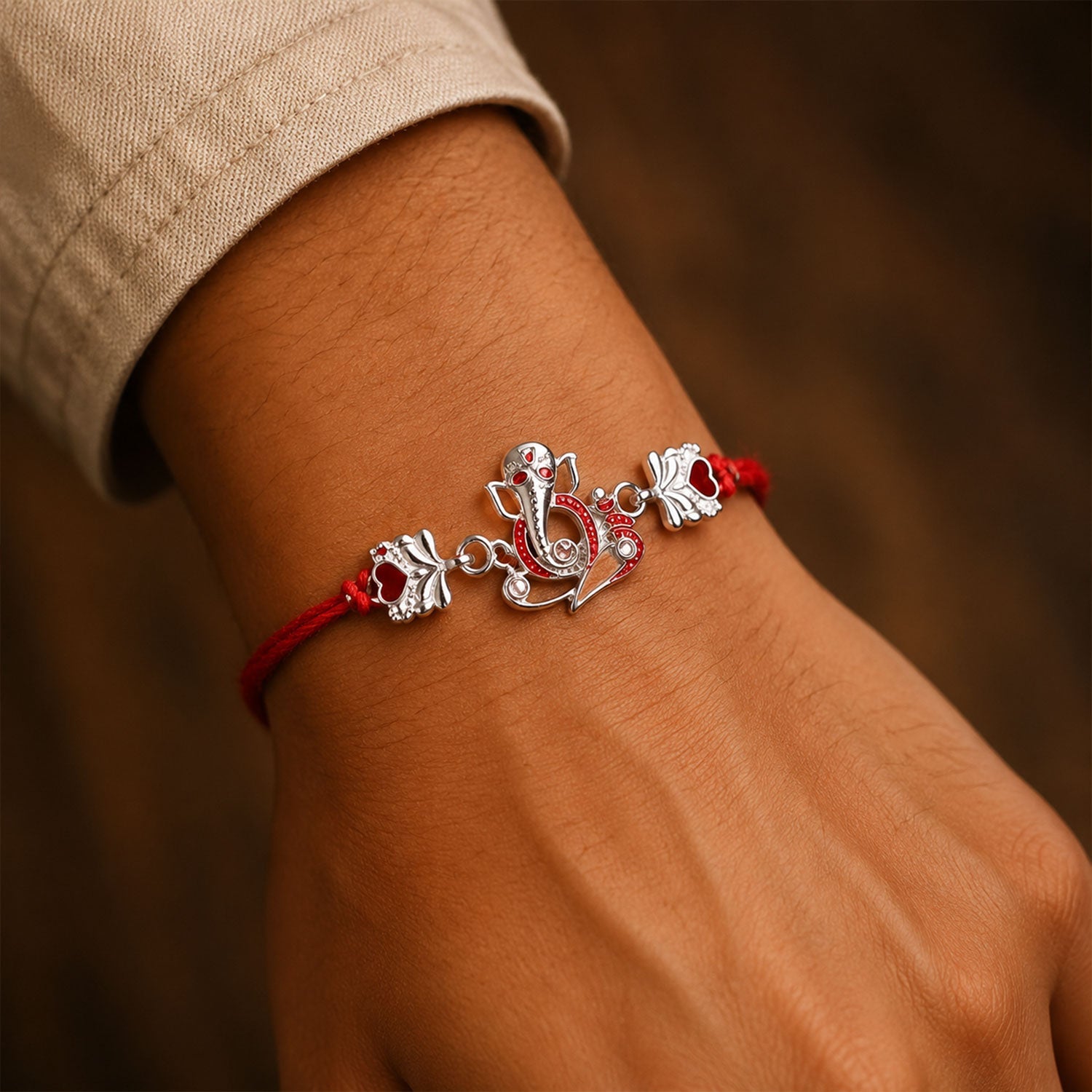 Close-up of Silver Ganpati Heart Charm on rakhi