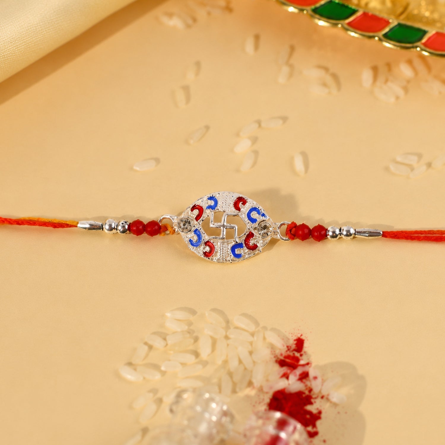 Silver Swastik Meena Oval Charm Rakhi with beads detailed close-up
