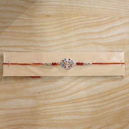 Silver Swastik Meena Oval Charm Rakhi with beads on festive background