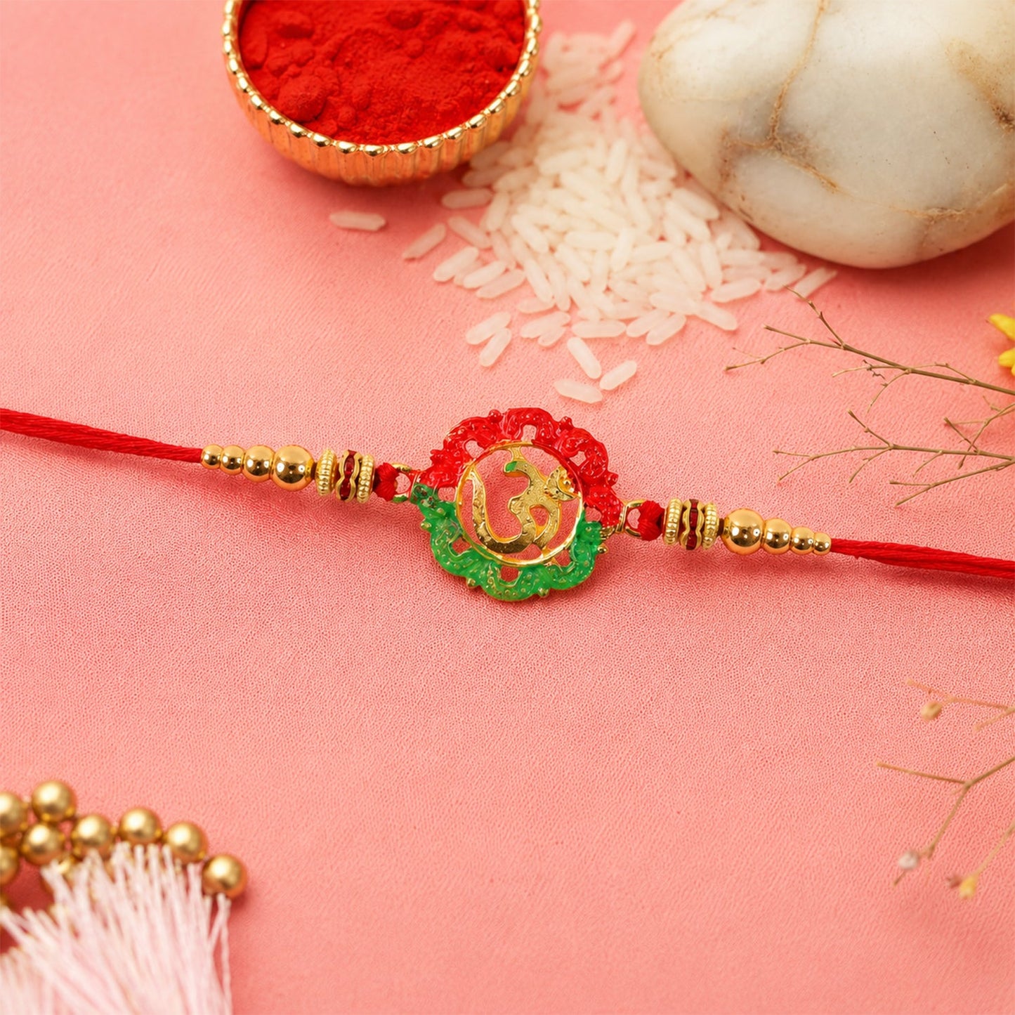 Golden Om charm rakhi tied on thread with beads