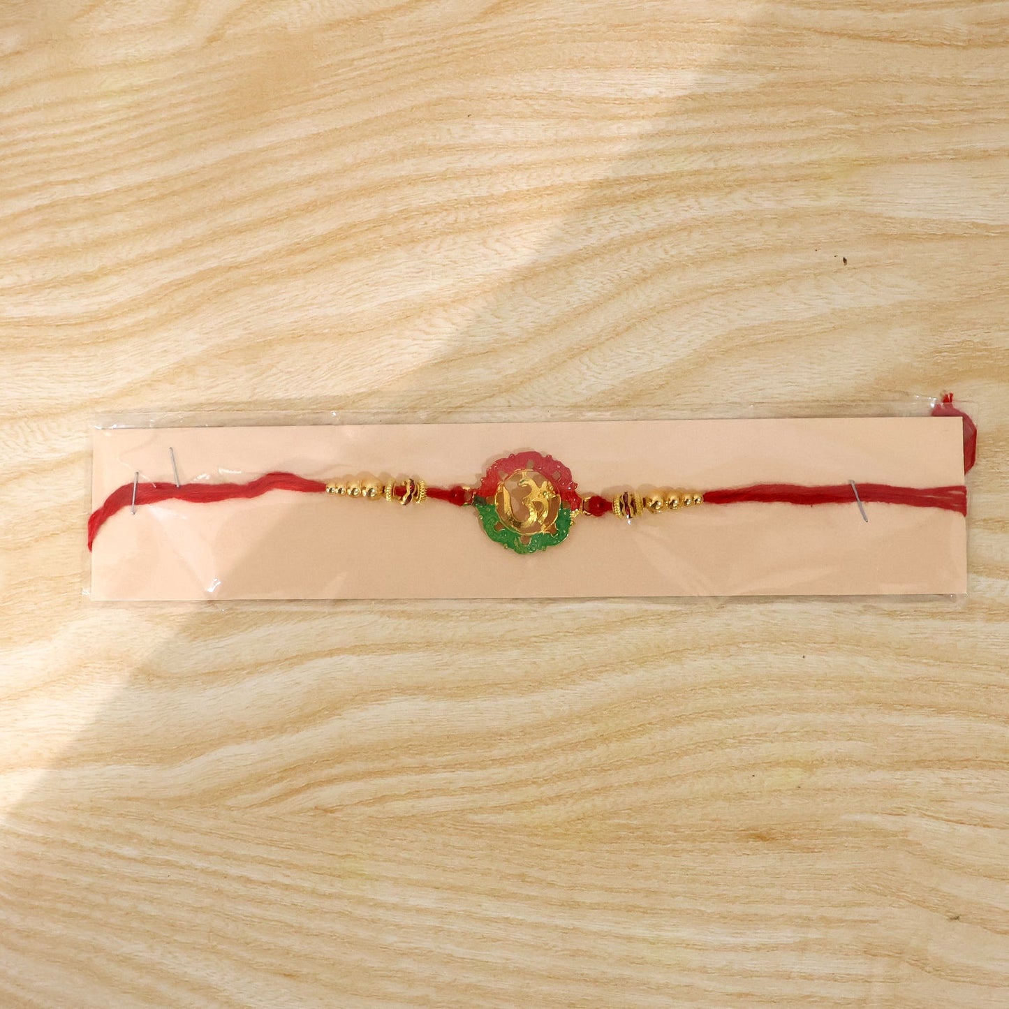 Elegant golden Om Meena charm rakhi on festive background