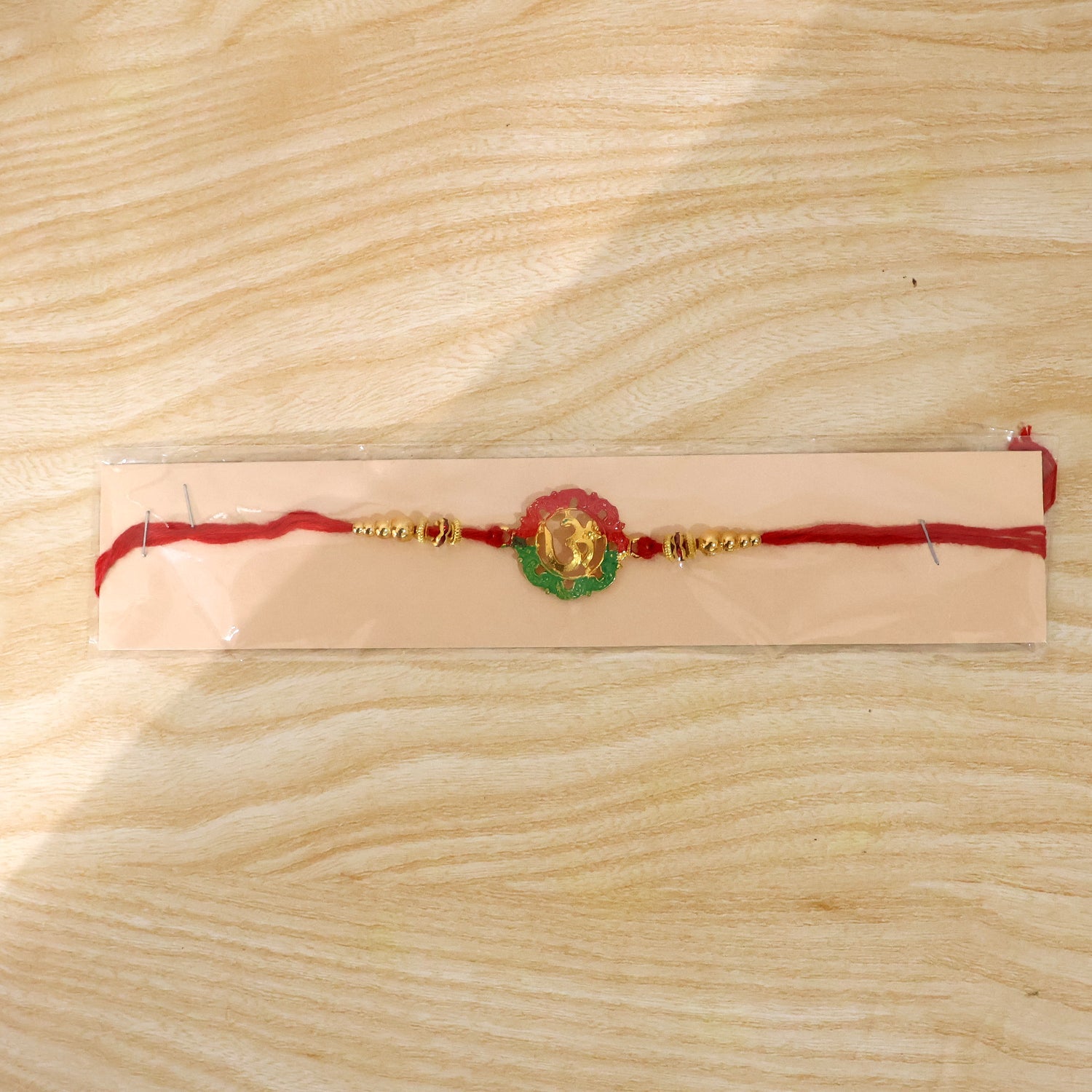 Elegant golden Om Meena charm rakhi on festive background