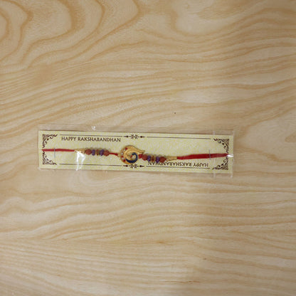 Detailed shot of decorative beads on Golden Mor Feather Rakhi