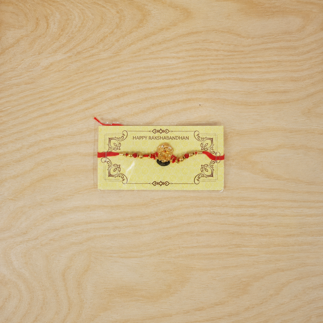 Golden Divine Face Charm Rakhi with pearl beads - top view