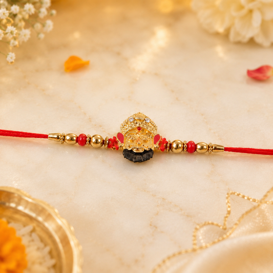 Full view of golden divine face charm rakhi with pearl beads