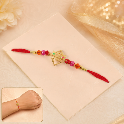 Golden Radha Krishna charm rakhi with crystal beads close-up