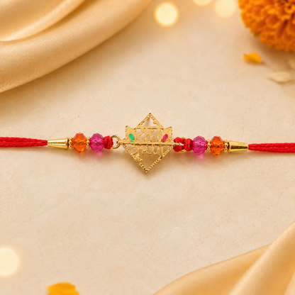 Close-up of golden Radha Krishna charm and crystal beads on rakhi