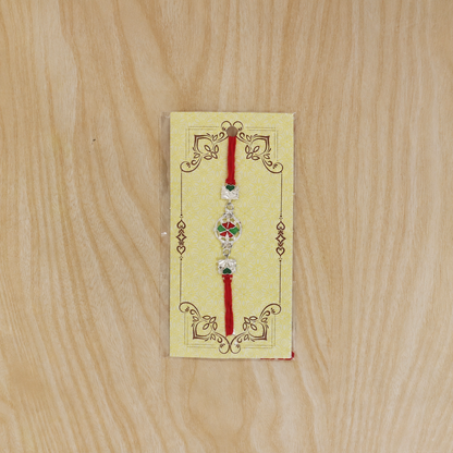 Silver pinwheel flower rakhi with decorative dori thread