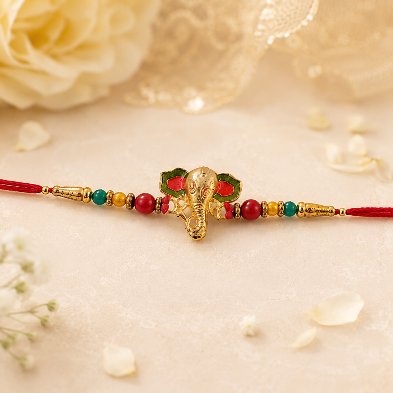 Golden Ganesha charm and thread on Rakhi showcasing intricate design