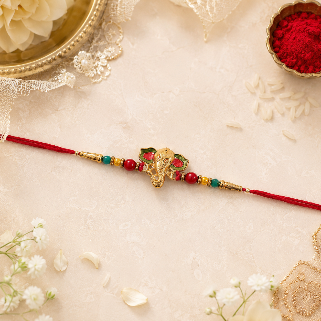 Close-up of golden Ganesha charm on rakhi with beads