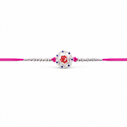 Top view of silver floral stone charm rakhi with beads, festival accessory