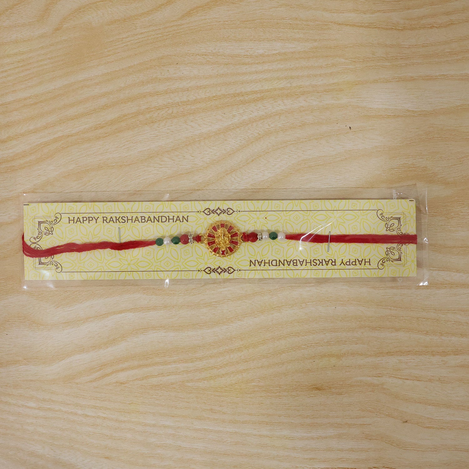 Golden Ganesha Wheel Rakhi with Red Enamel