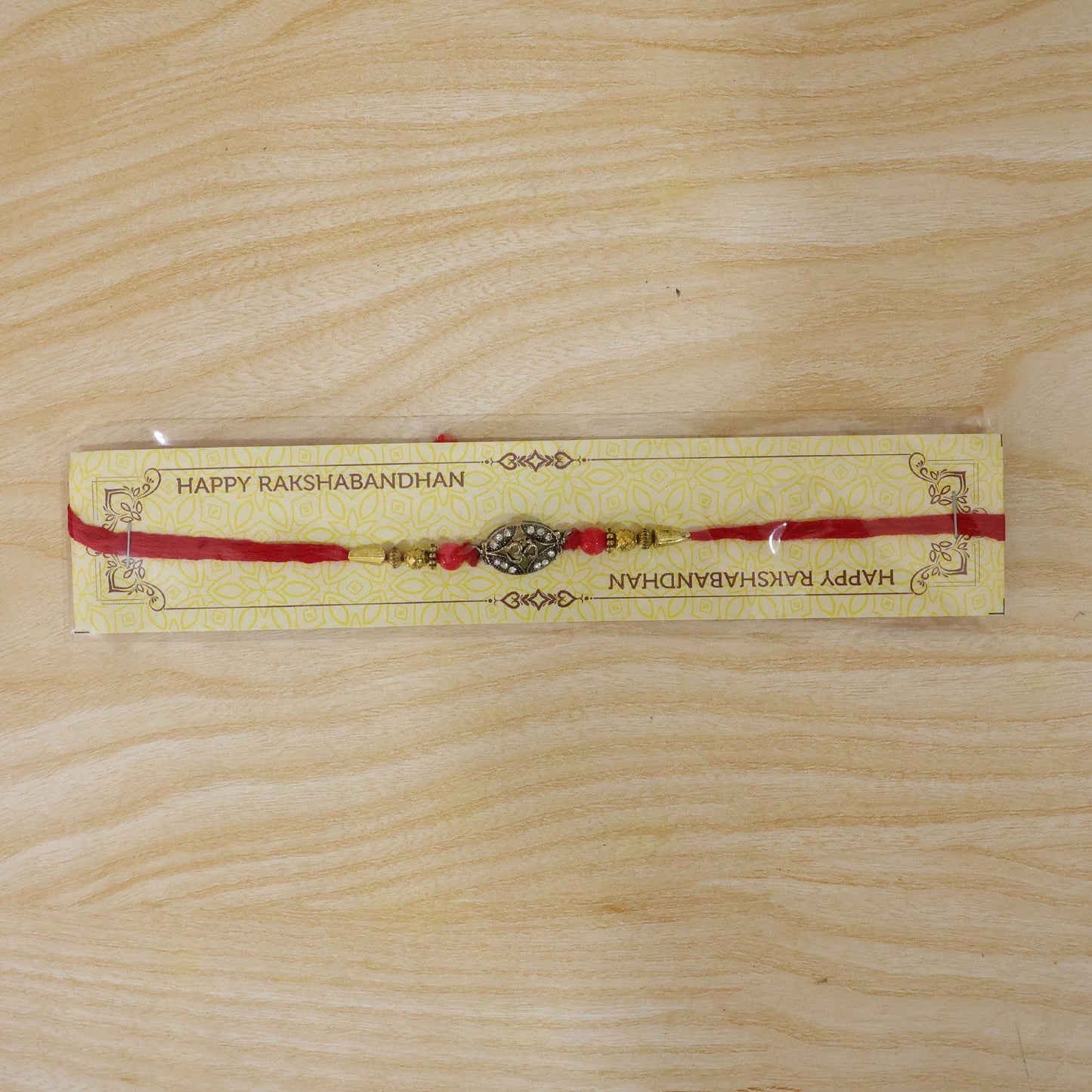 Antique Golden 'Om' Oval Rakhi