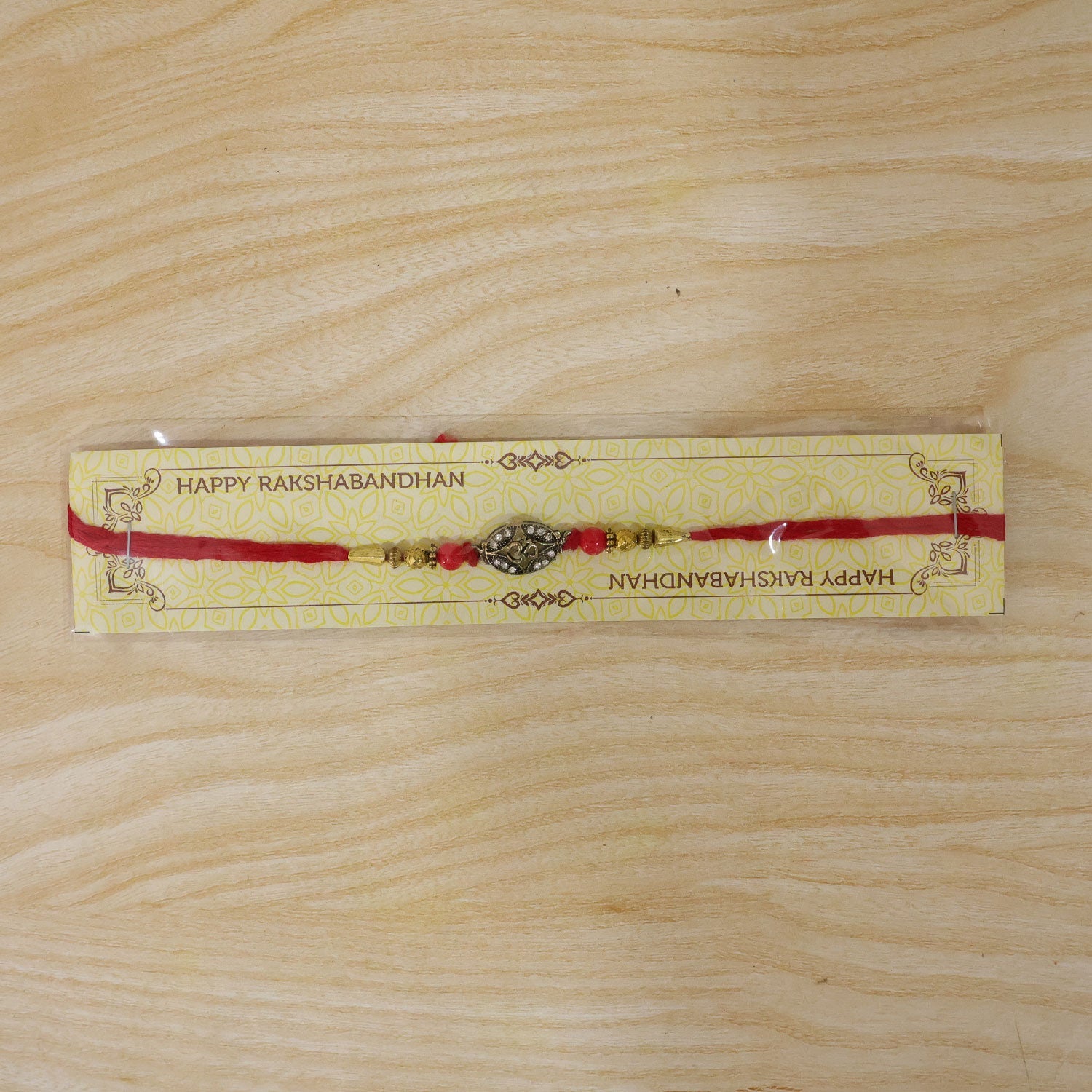 Antique Golden 'Om' Oval Rakhi