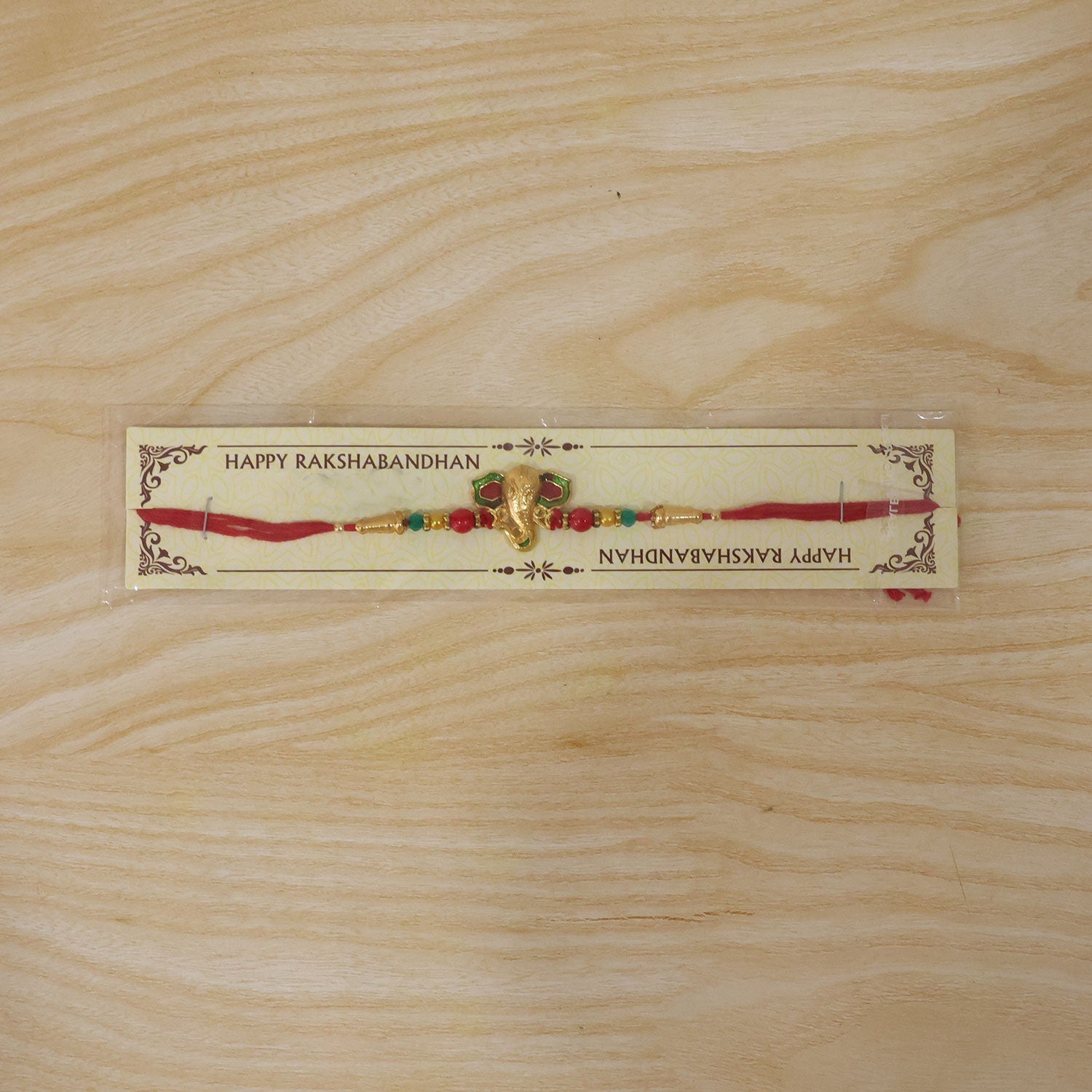 Lord Ganesha Golden Meenakari Rakhi with Red & Green Beads for Brother