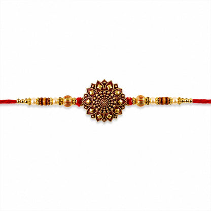 Close-up of the red thread and golden beads of the Rakhi
