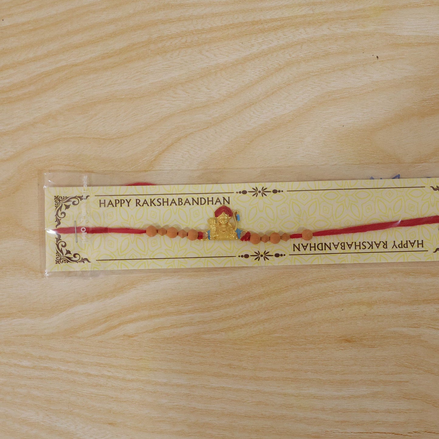 Auspicious Golden Deity Rakhi with Sandalwood Beads for Brother