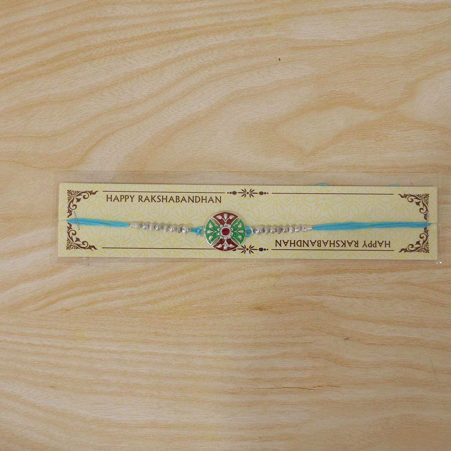 Meenakari Rakhi with floral pattern & blue thread for brother