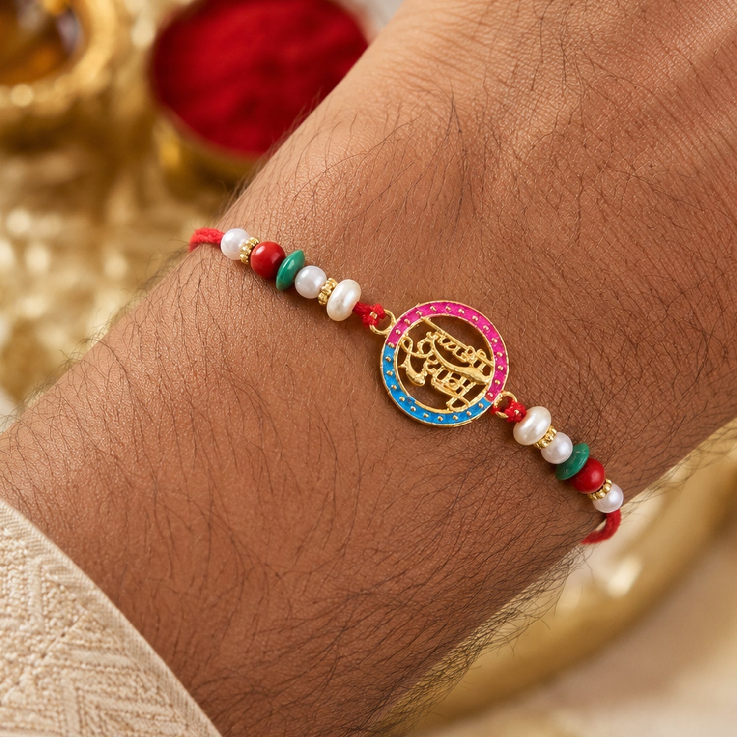 Golden Jay Shree Shyam Rakhi with pearl accents, angled view