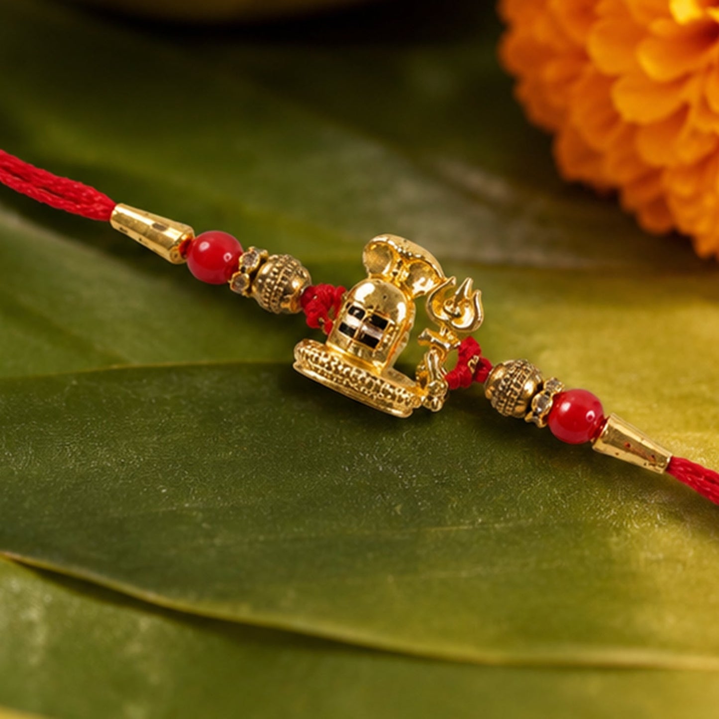 Traditional Golden Antique Shivling Motif Rakhi with Red Beads for Brother