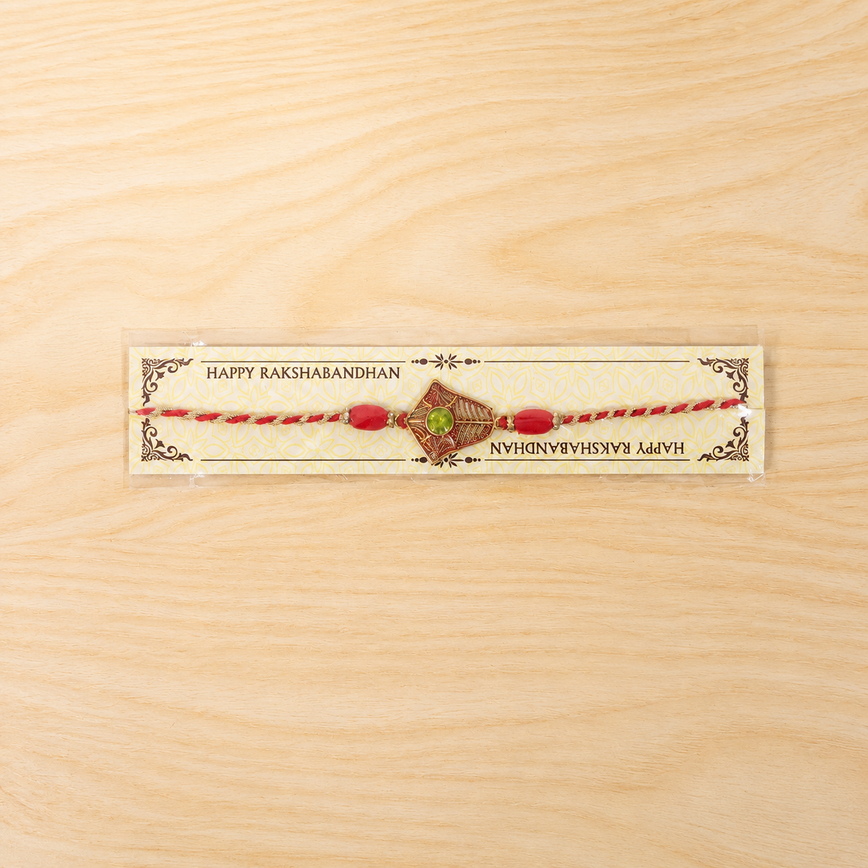 Golden Floral Rakhi with Green Stone & Red Beads for Brother