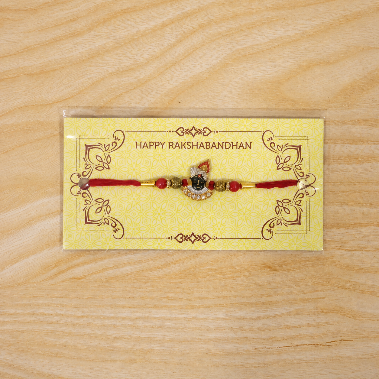 Divine Face Rakhi with AD Stones & Red Beads for Brother