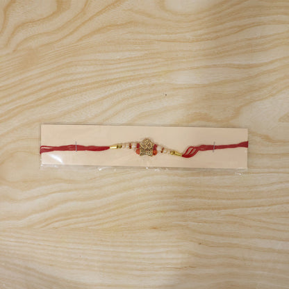 Traditional Golden Om Rakhi with Rudraksha & Pearls for Brother