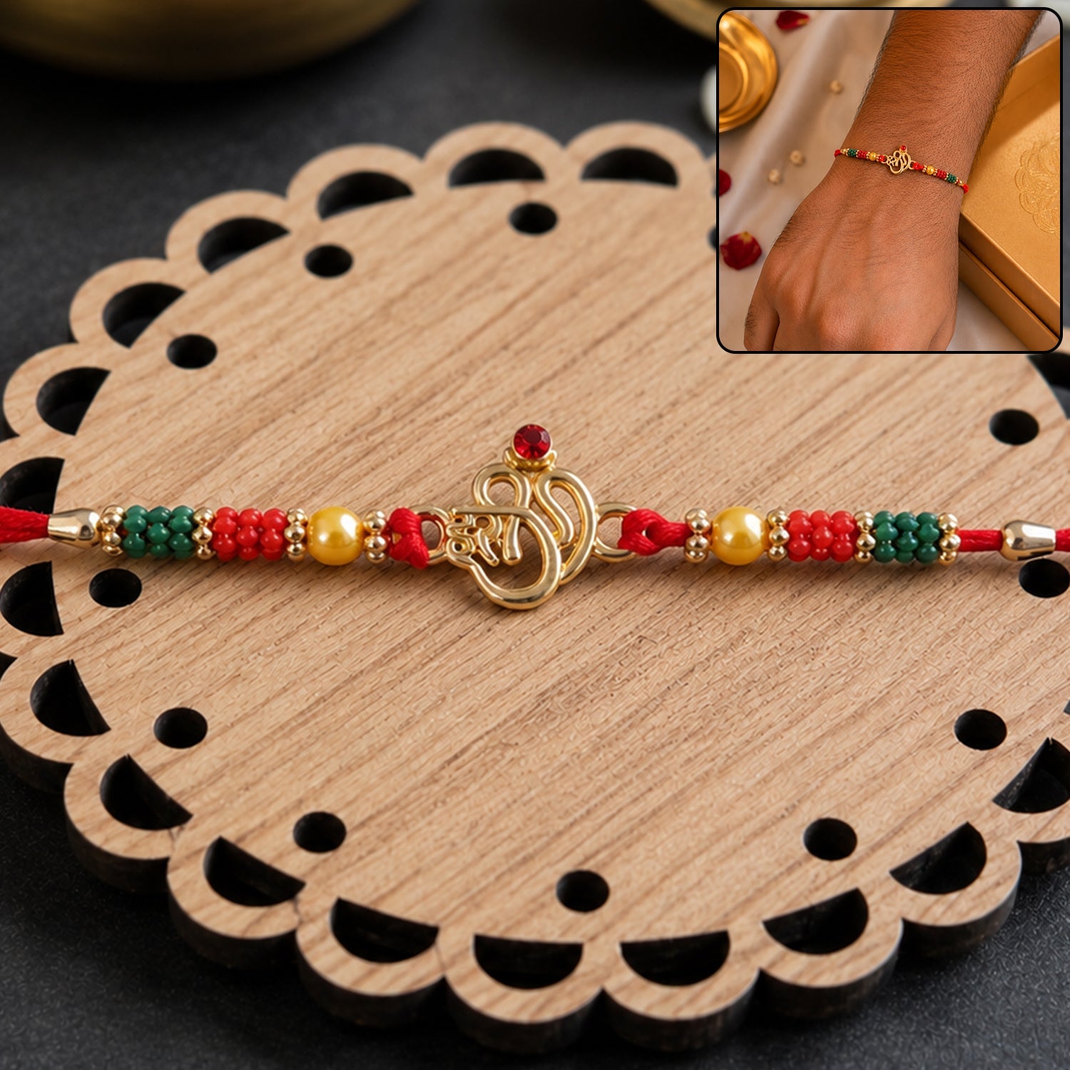 Golden Om (?) Rakhi with Red & Green Crystal Beads