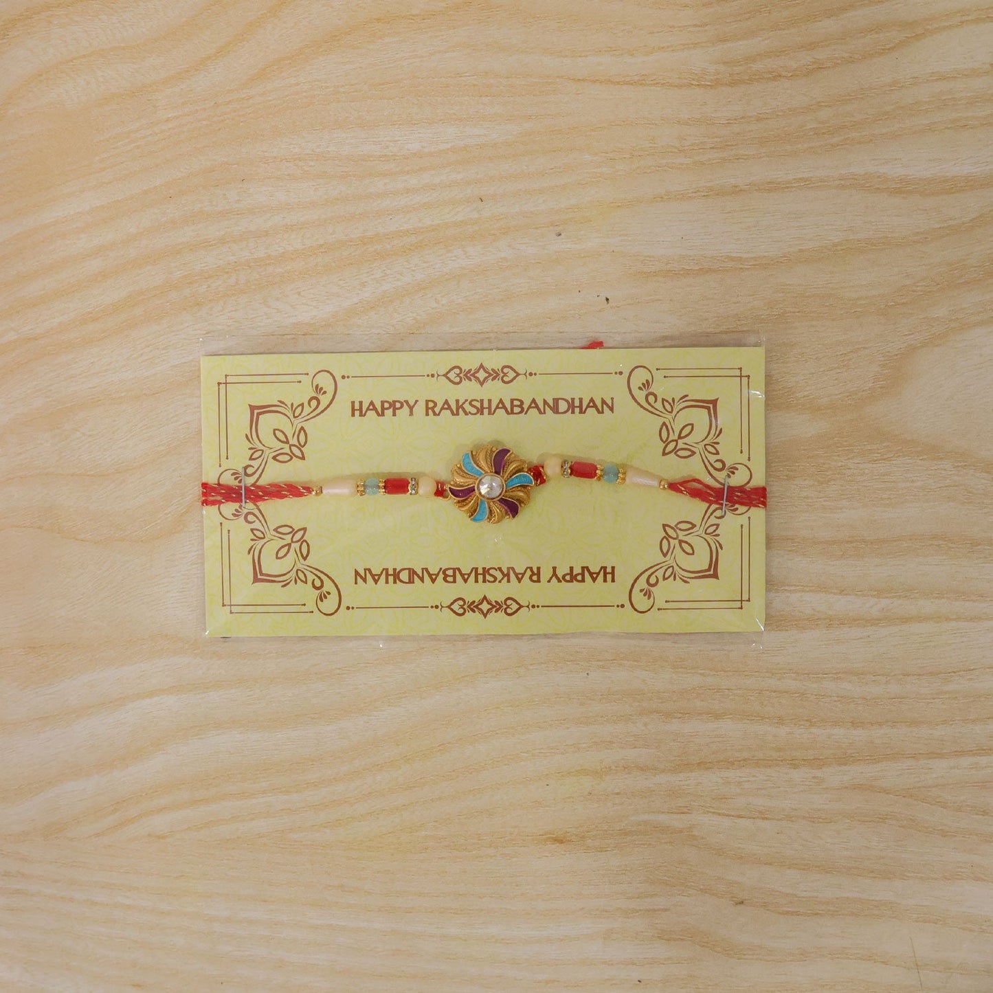 Golden Meenakari Pinwheel Rakhi with Enamel & Diamond Stone