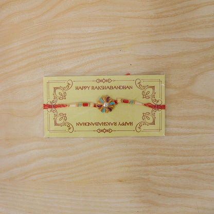 Golden Meenakari Pinwheel Rakhi with Enamel & Diamond Stone
