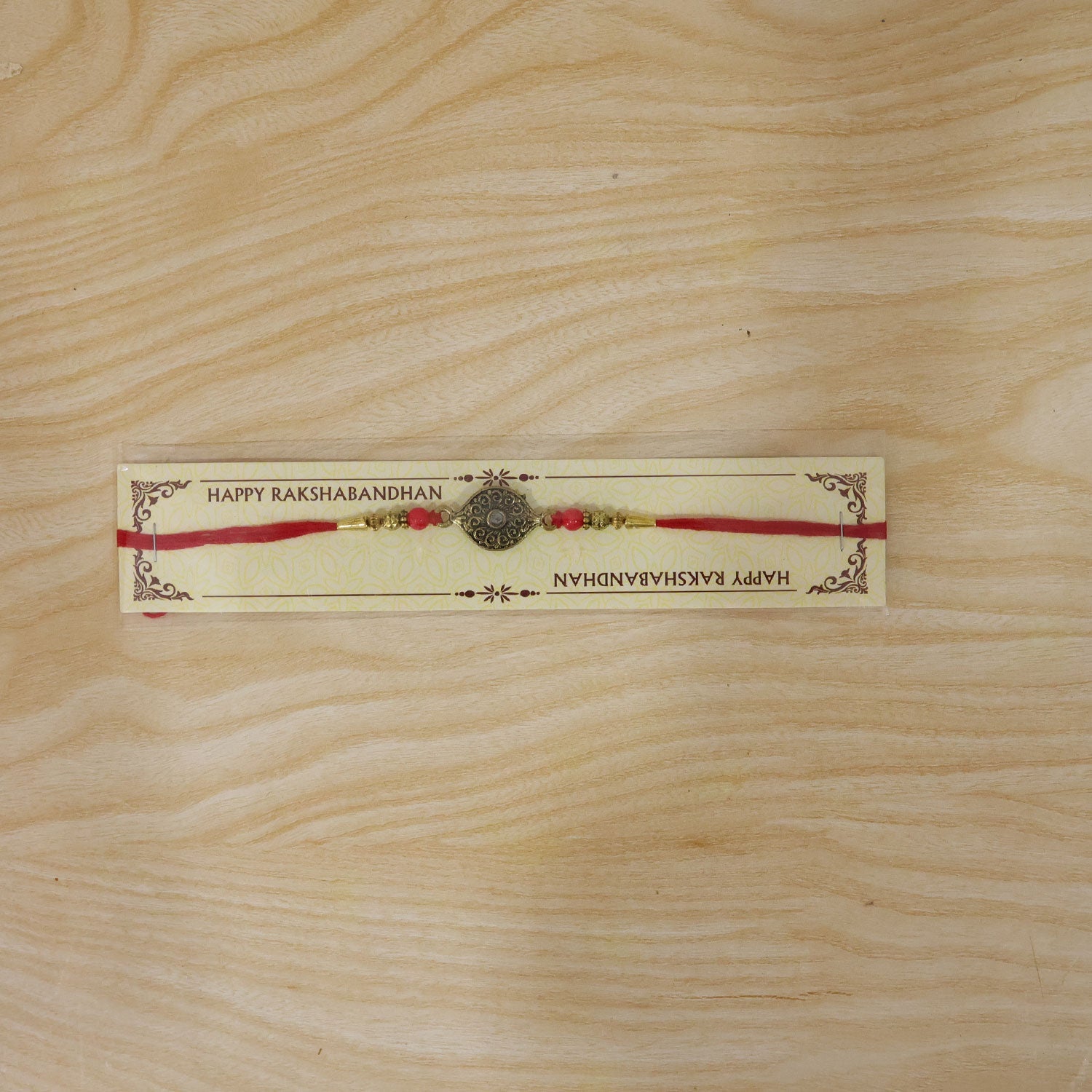 Antique Oval Rakhi with Red Crystal Beads for Brother