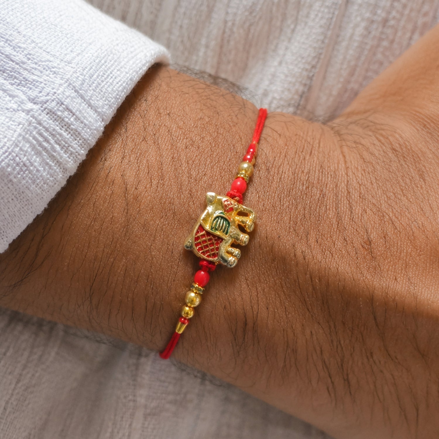 Gold Elephant Charm Rakhi with Red Thread & Beads