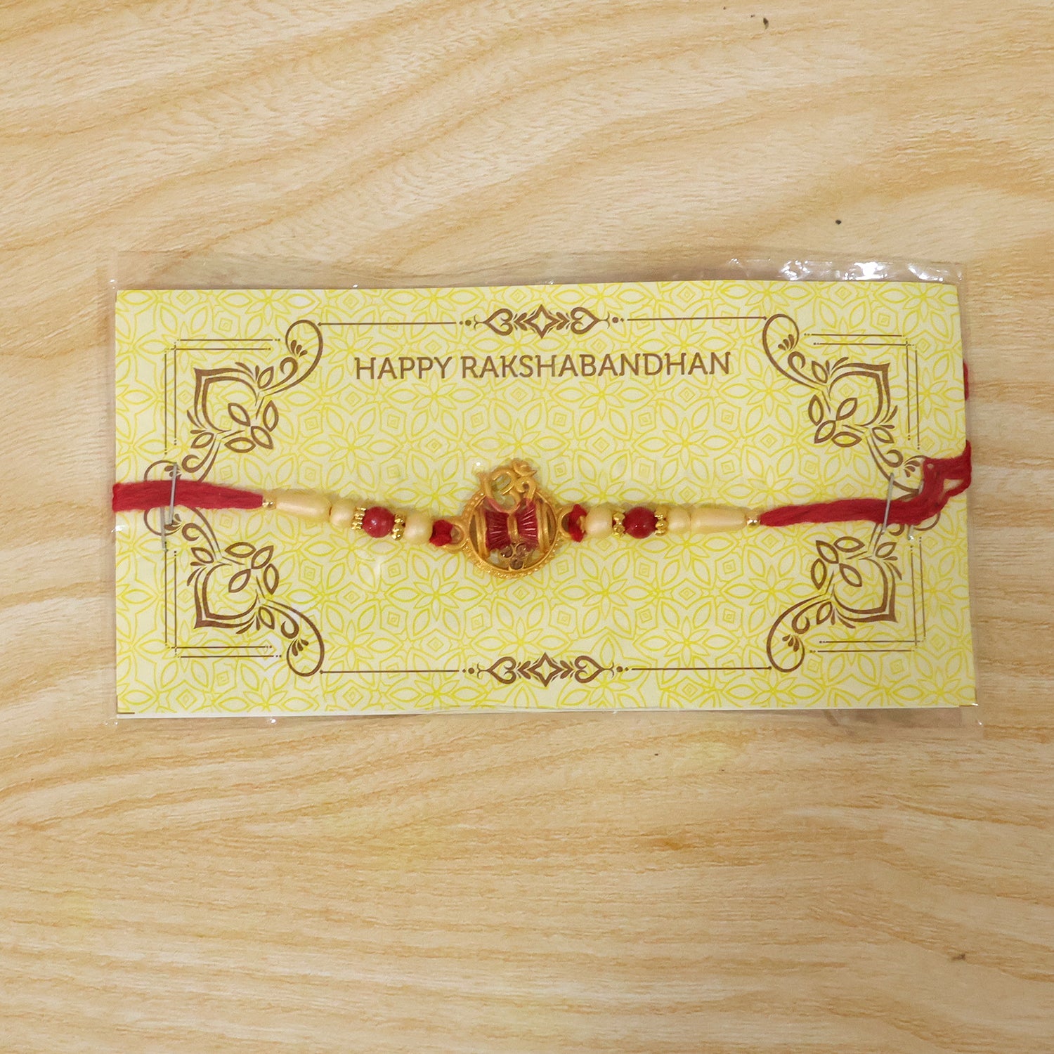 Back view of Om Damaru Charm Red Thread Rakhi with pearl beads