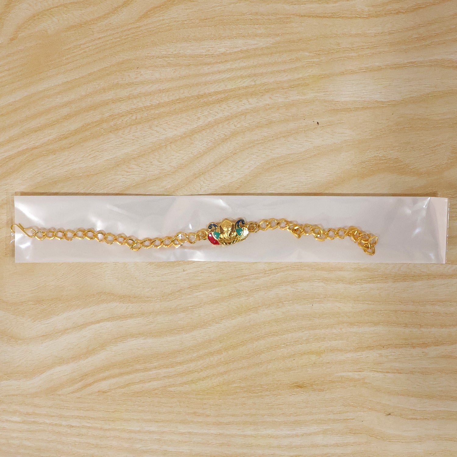 Festive rakhi showcasing Peacock Ganesh charm and thread