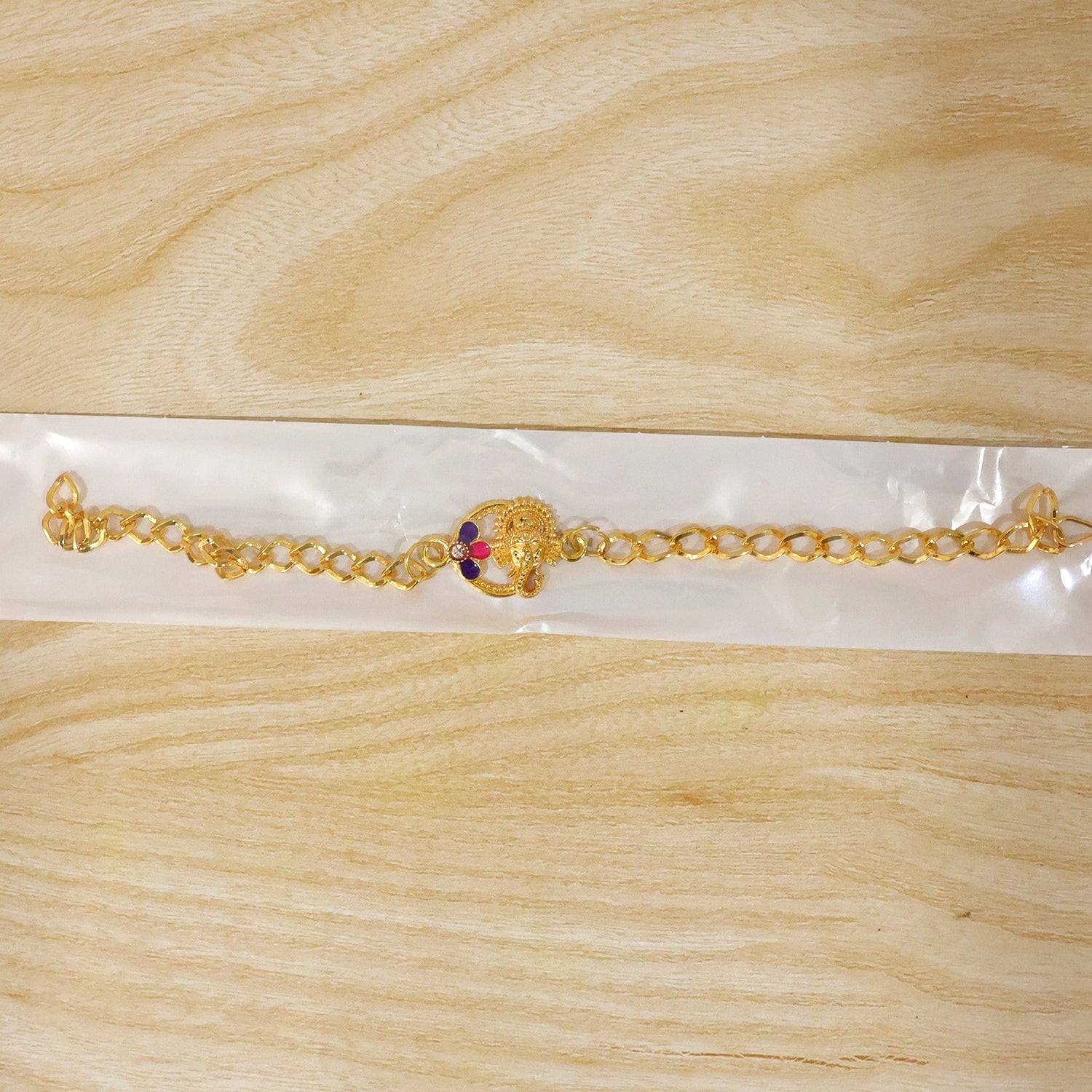 Lord Ganesha gold tone rakhi bracelet styled on wrist