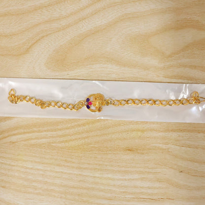 Lord Ganesha gold tone rakhi bracelet styled on wrist