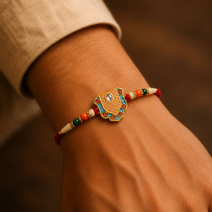 Close-up of designer enamel gold tone Rakhi showing intricate details