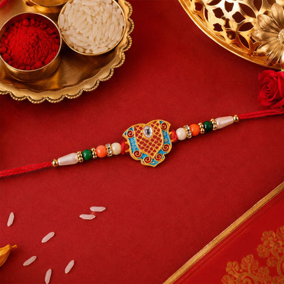 Top-down view of premium gold tone Rakhi for Raksha Bandhan