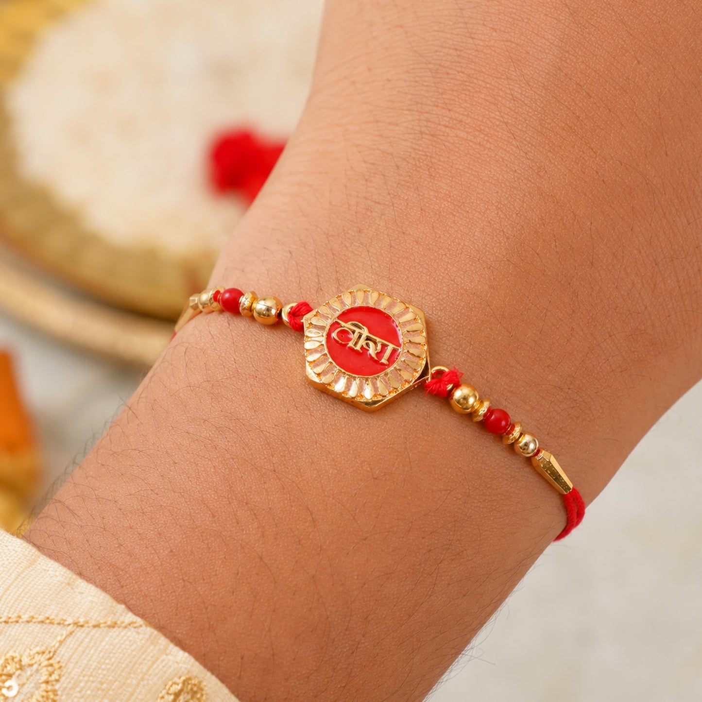 Veera Red Enamel Rakhi tied on a brother's wrist
