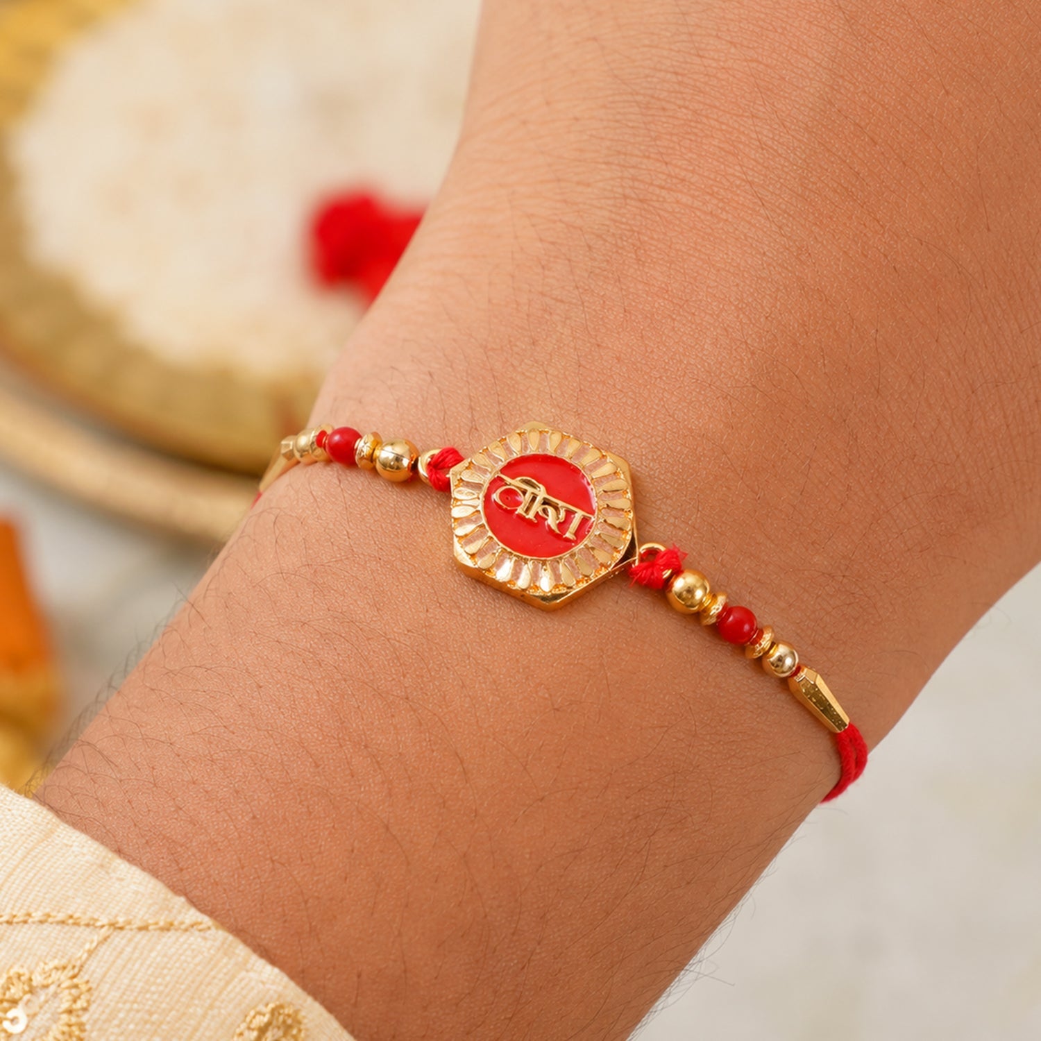 Veera Red Enamel Rakhi tied on a brother's wrist