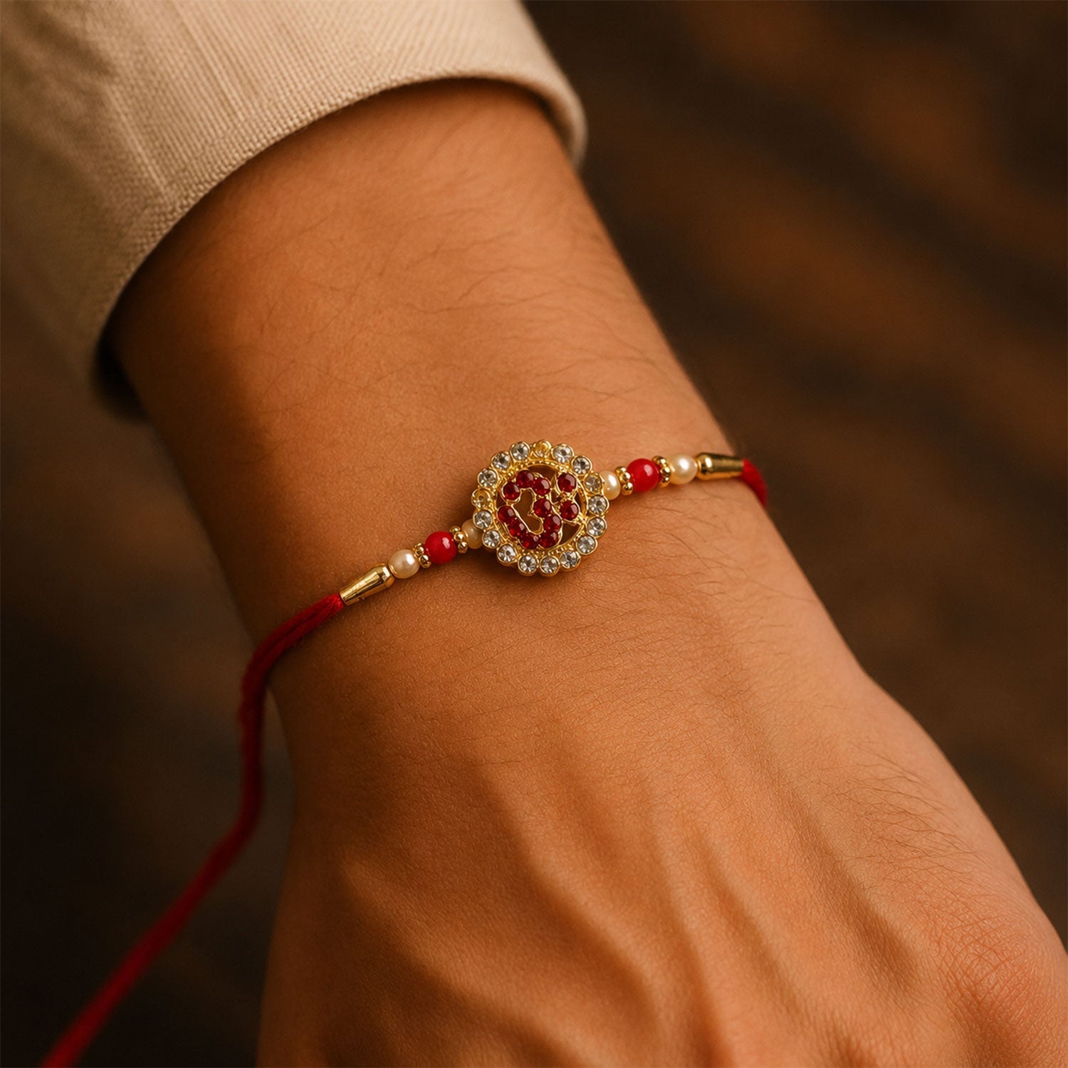 Close-up of Om Stone Studded Gold Tone Rakhi design